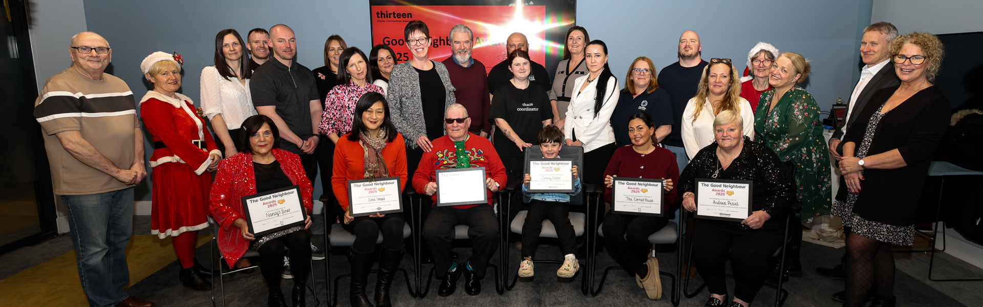 Attendees and organisers of the Good Neighbour Awards pose in a group photo with winners and runners up holding their certificates at the front