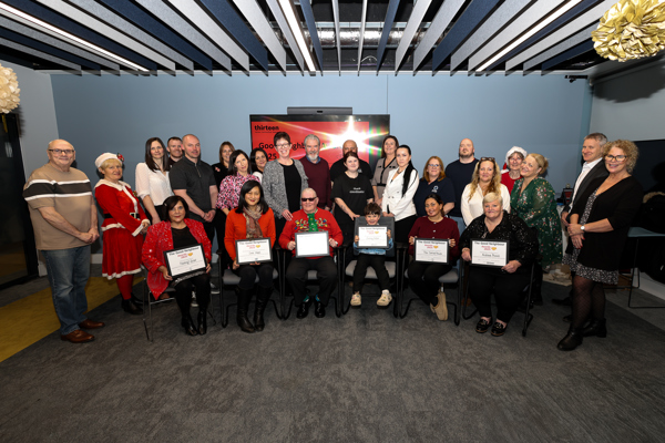 Attendees and organisers of the Good Neighbour Awards pose in a group photo with winners and runners up holding their certificates at the front