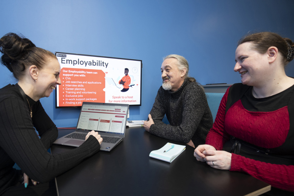 A couple speaking to an employability case worker