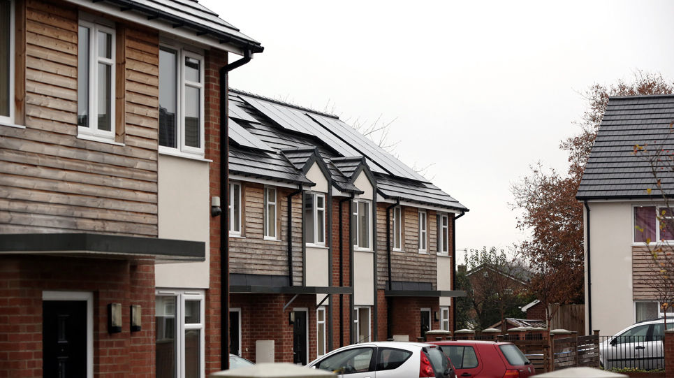 A row of residential houses with cars outside