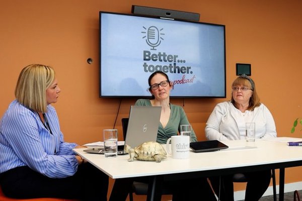 Thirteen staff member and two customers discussing stigma in social housing