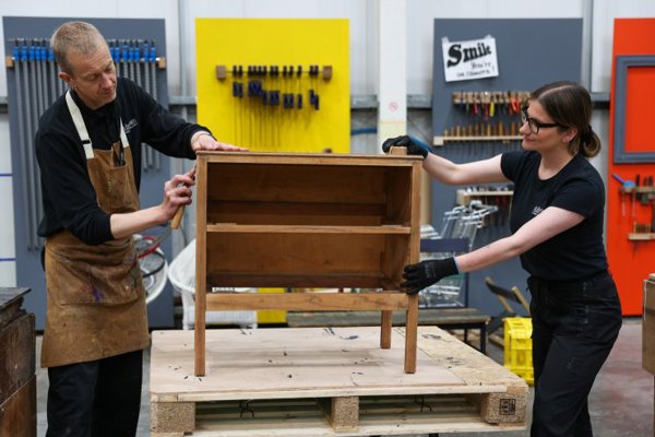 The upcycling team working on a wooden cabinet in the upcycling workshop