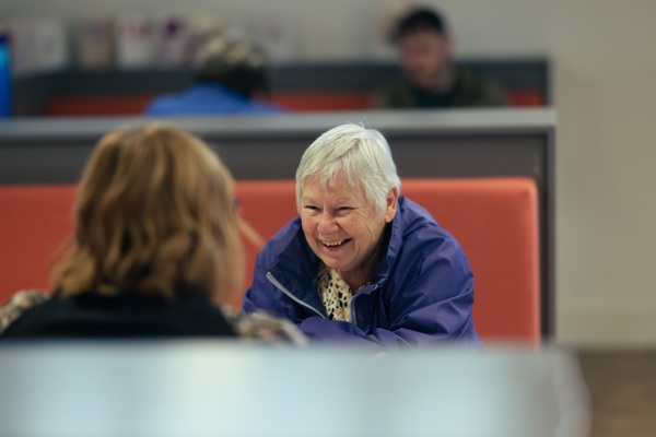 A customer smiling at a Thirteen staff member