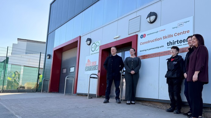 Colleagues from Middlesbrough College and Thirteen Group stood in front of the new construction skills centre sign