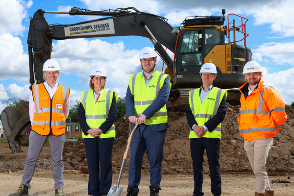 Representatives from Thirteen, RE:GEN and the Middlesbrough Mayor standing on site at the new Thorntree housing development with a digger in the background