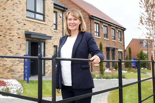Sharon Thomas standing in front of new build homes