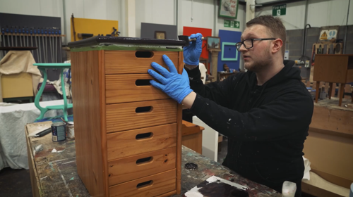 Kyle Wilson puts a lick of paint on a set of drawers