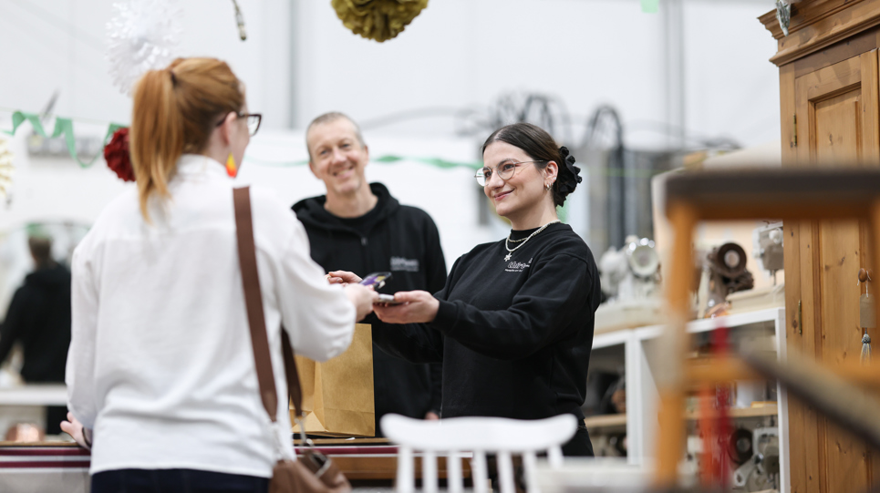 A lady buying an item from Thirteen's upcycling shop
