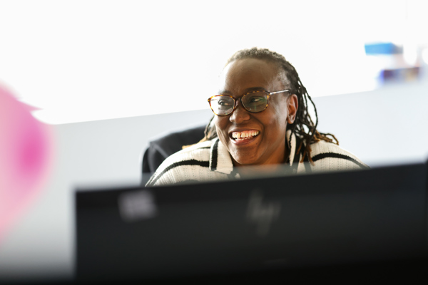 Touchpoint advisor smiling at another colleague whilst at her desk
