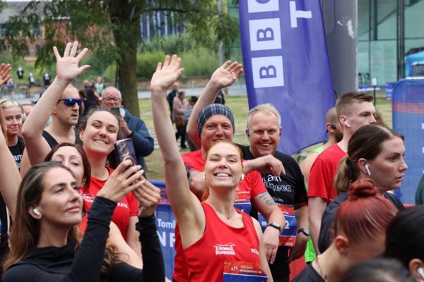 Runners smile and wave at camera at the Middlesbrough 10K start line