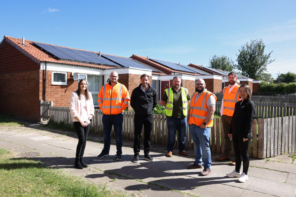 Thirteen and GEC Power Ltd representatives outside bungalows at Gleneagles Court where solar panels have been installed