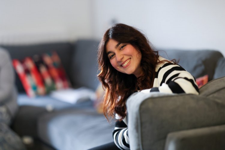 Customer smiling on sofa in their new home